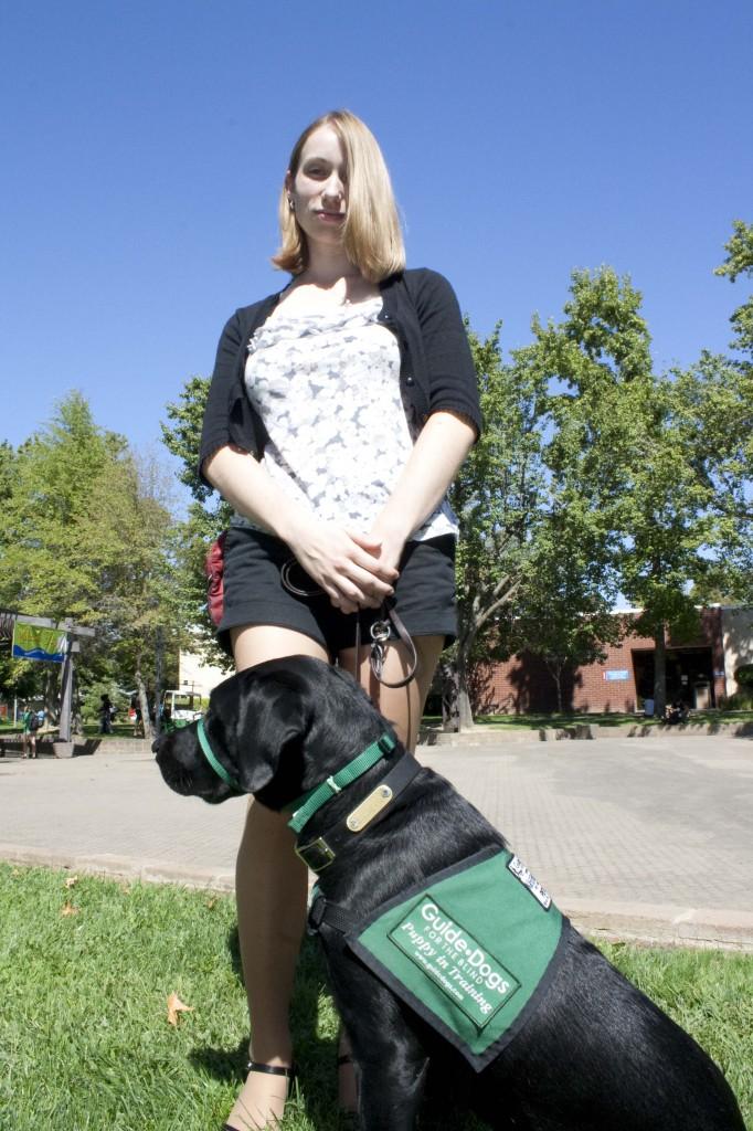 Jennie Nickel walks Clement, a puppy in training for a guide dog program, through the ARC campus. (Photo by Bryce Fraser)