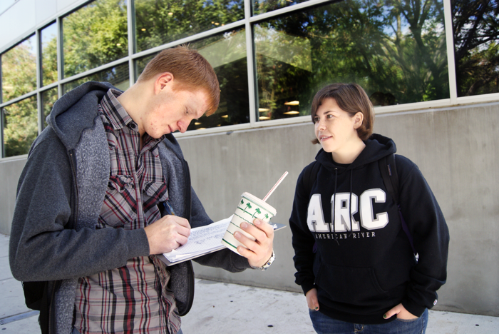 Kate Clark watches 18-year-old music major Igor Vnydyuk sign her petition to make American River College a smoke-free campus on Tuesday, Oct. 5, 2011. (Photo by Shanel Royal)