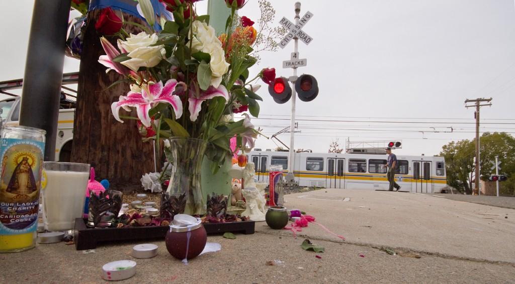 A southbound Meadowview line train travels behind a memorial placed near the crash site of an SUV driven by Louis Williams on Jan. 28. (Photo by Bryce Fraser)