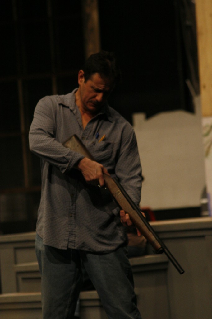 Brandon Lancaster as Atticus Finch with a prop rifle during rehersal on Feb. 13. (Photo by Bryce Fraser)