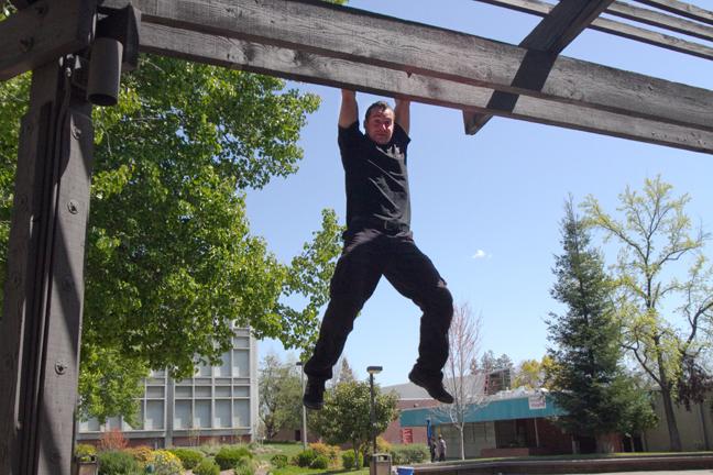 Dangling from a beam in Rose Marks Pavillion, Bayland Rippenkroeger, a former running back for the Beavers football team, is now following in his familys footsteps as a stuntman in Hollywood. He is currently in the Water World show at Universal Studios, Hollywood. (Photo by Stephanie Lee)