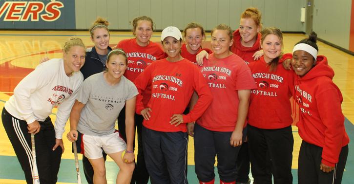 Women’s Softball coach Lisa Delgado (center) and a few of her student athletes in the gym for a rainy day practice on Wednesday, March 20, 2013.