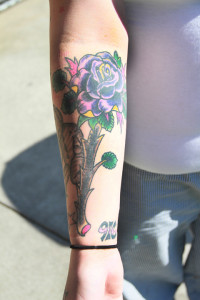 Celah Adkins shows a cover up tattoo of a rose on her right forearm