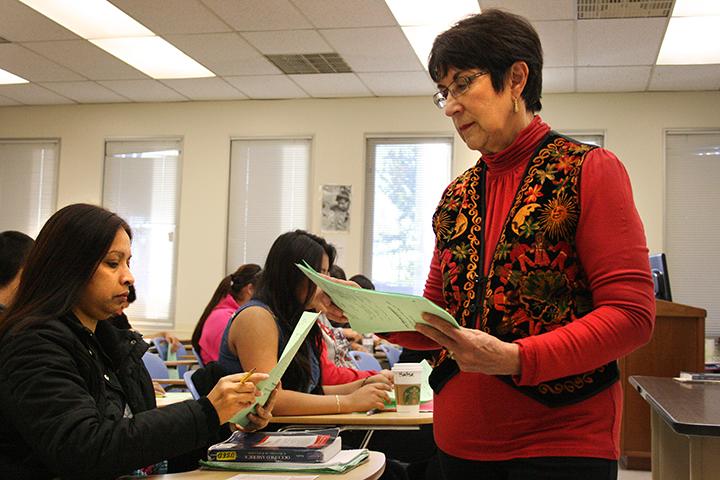 Professor Delgado-Campbell passes out a quiz to her students after announcing cultural events they may attend to help them better understand the course.