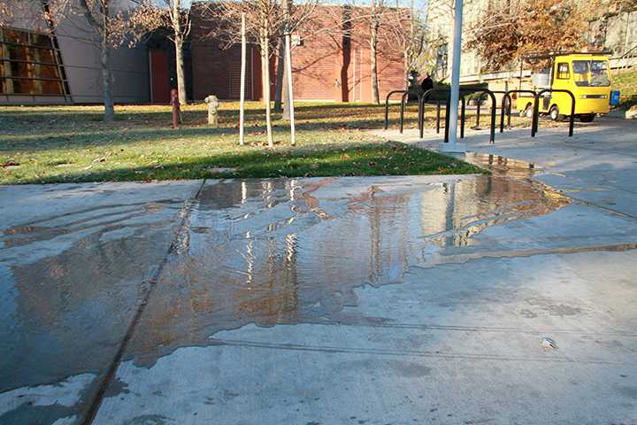 A broken pressurized sprinkler spills water on the pavement behind the Liberal Arts building this morning when temperatures were below freezing, creating a potential ice slick on campus.  