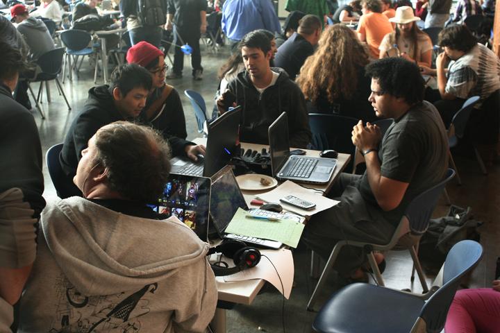 (Left to right) Dong Hao Zheng, Samuel Mantei, and Ken Menifee in a busy cafeteria, playing League of Legends cooperatively. Multiplayer games like LoL require coordination and teamwork, making the cafeteria a good place to communicate with team mates in a live environment.