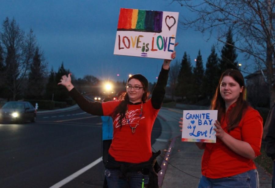 Current and former presidents of ARC Fierce Lydian Countryman, left, and Kindra Pring, right, hold up homemade signs outside of Granite Bay High School on Thursday night in support of the schools newest drama production, The Laramie Project. (Photo by Emily K. Rabasto)