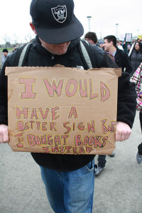 American river current co-editor-in-chief Ed Gebing carries his sign advocating for affordable education during the March in March rally on March 3.