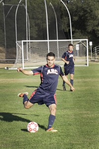 Julio Vizcarra a midfielder kicks the ball to a teammate downfield.