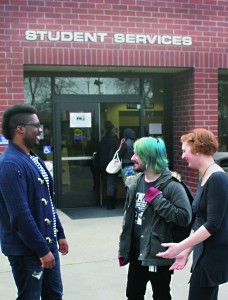 Student helper and part-time clerk Brandon January, 25, relays financial aid information to passing students Billow Bowles, 28, majoring in Art New Media, and Alycia Riggins, 27, majoring in Funeral Services.