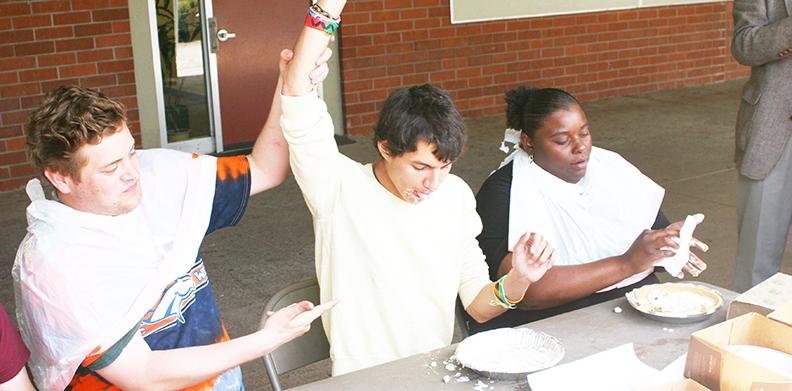 Richard Martel raises the hand of Colton Dargue, winner of the pie eating contest. The contests was one of the events and games that math department prepared for the Pi Day celebration that took place at ARC’s Math Quad on Mar. 12. Dargue, in addition to winning a pie-eating contest, also completed a Pin The Decimal game and a math puzzle.