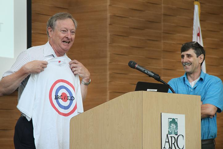 John Gamber, left, receives a shirt from fellow employee Randy Schuster at ARCs Fall 2015 Convocation for consistently hitting the target. Said Gamber: As someone who wore camouflage for 15 years, I cannot tell you how nervous this makes me. (Photo by Kameron Schmid)