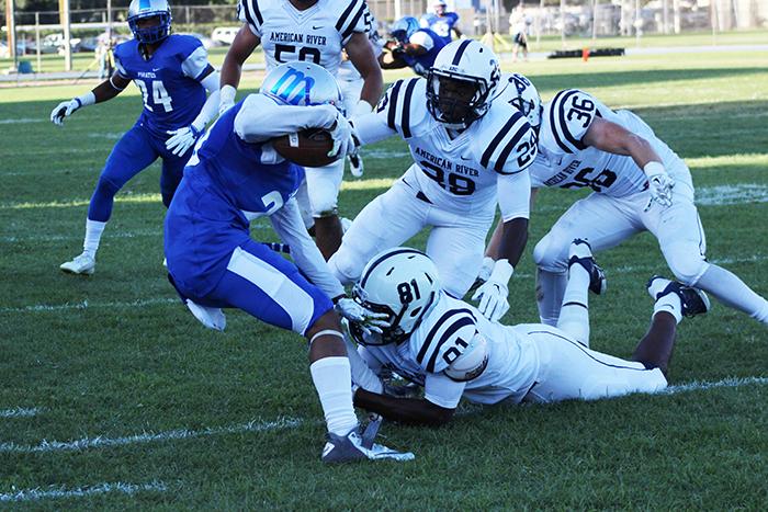 Modesto Junior College defensive back Lesean Collins is tackled by American River College wide receiver Malik Dumetz after intercepting a pass from ARC qaurterback Chris Guillen during the season opener on Sept. 5, 2015. ARC blamed the loss on  a poor week of practice. (Photo by Barbara Harvey)