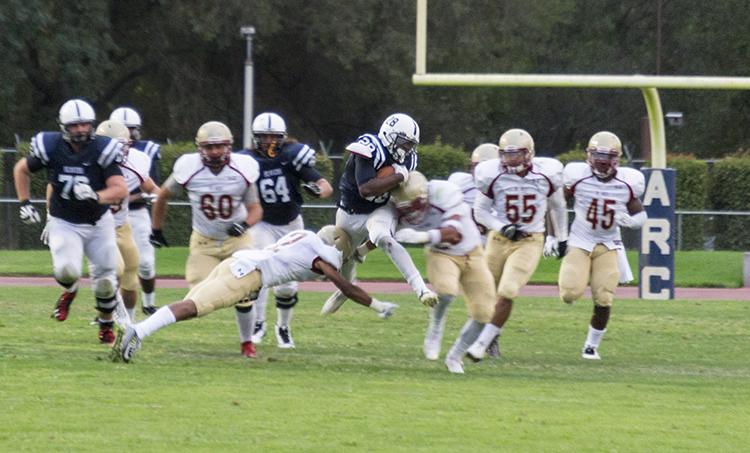 American River College running back Armand Shyne breaks tackles from De Anza defenders on Saturdays win 38-2 win over De Anza College on Saturday, Sept.12 2015. Shyne finished the game with 131 yards rushing. (photo by Joe Padilla)