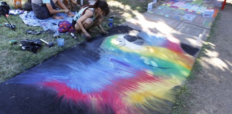 Zea Marubashi works on her portrait of a parrot at "Chalk It Up." This year was Marubashi's eleventh year at the event and sixth year next to the same chalk artists.