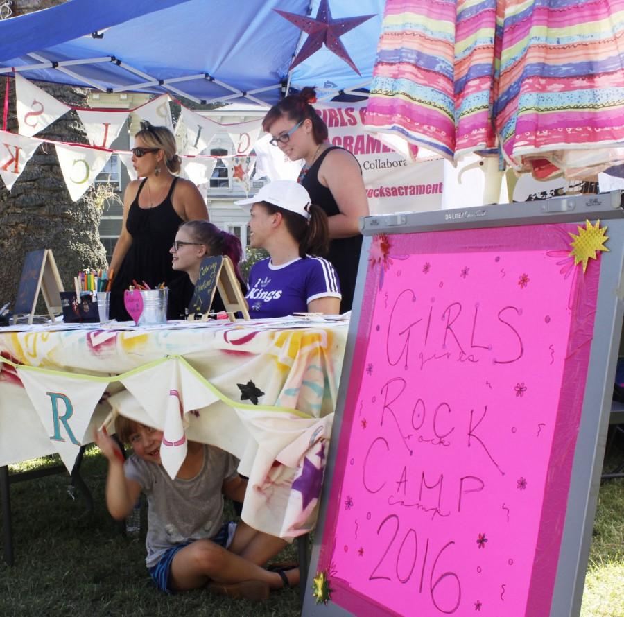 Top, Larisa Bryski, Jojo Mimmick, Rachel Mimmick, Emma Simpson and underneath the table Laynie Seltzer work the table at Chalk It Ups 25th annual art festival on Labor Day weekend in Fremont park, downtown Sacramento. Girls Rock Sacramentos goal was co-founded created to empower young women, and those who identify as female, through music and to deconstruct gender roles through team building exercises and events.