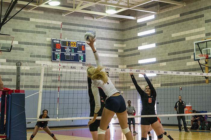 American River College setter Monica Udahl smacks the ball over the net as two Lassen players stretch out to defend the play. ARC won the second game of the match 25-12 on Aug 28, 2015. (Photo by Joe Padilla)