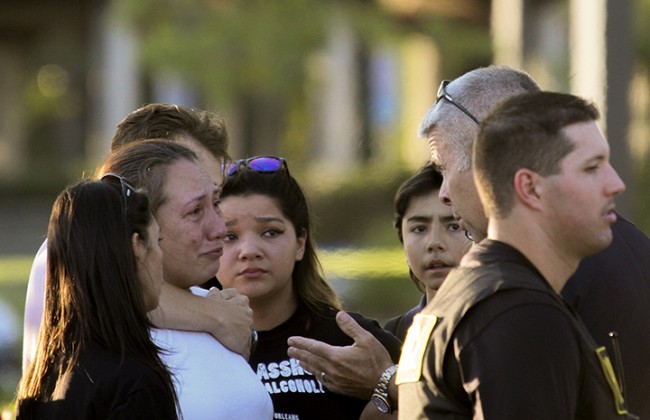 A police officer talks to Davida Trejo, the mother of shooting victim Roman Gonzalez, 25, on Thursday after the on campus shooting at Sacramento City College that left Gonzalez dead and two other students injured. (Photo by Ashlynn Johnson)