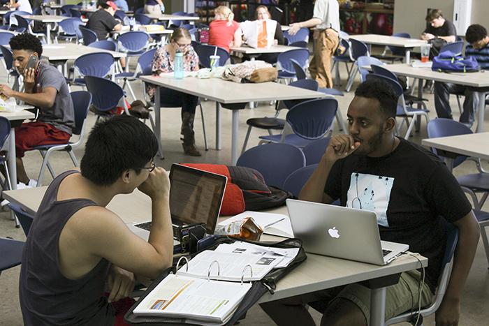 American River College student Brian Wong, left, works on homework in the Student Center with his friend Israel Solomon, a UC Riverside alum who visited Wong on campus. Wong said that he only uses the WiFi in certain areas of the campus. (Photo by John Ferrannini)