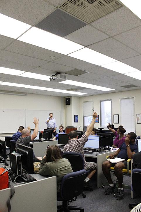 Students participate by raising their hands during Professor Michael Spurgeons American River Review class. The ARR course is based around reviewing student submissions such as poetry, fiction, creative non-fiction etc. and active involvement is expected. (Photo by Cheyenne Drury)