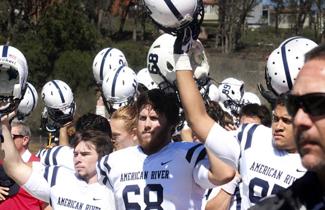 American River College offensive lineman Taylor Olenslager stands front and center while him and the team raise their helmets at the end of the national anthem on Sat. Sept. 26 during their game against City College of San Francisco. ARC went on to win the game 20-17. (Photo by Ashlynn Johnson)