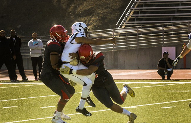 American River College’s quarterback Jihad Vercher getting tackled by City College of San Francisco defensive ends Rod Jones and Austin Larkin during ARC’s 20-17 win over CCSF on Sat. Sept. 26, 2015. The game ended with ARC beating CCSF 20-17. (Photo by Ashlynn Johnson)
