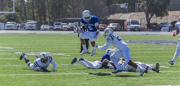 College of San Mateo slot receiver David Rango leaps over his own player before being tackled by American River College safety Robert Sanders during ARCs 42-10 loss to CSM on Oct. 3, 2015. CSM ran for 298 yards against ARCs defense. (photo by Joe Padilla)
