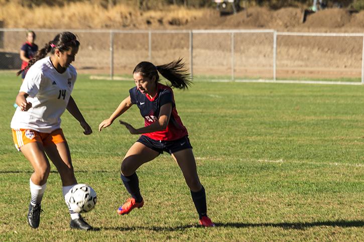 American River Colleges Jocelyn Tamayo fights for the ball against Cosumnes River Colleges Taylor Arlin during its match at ARC on Oct 16.  (Photo by Joe Padilla)