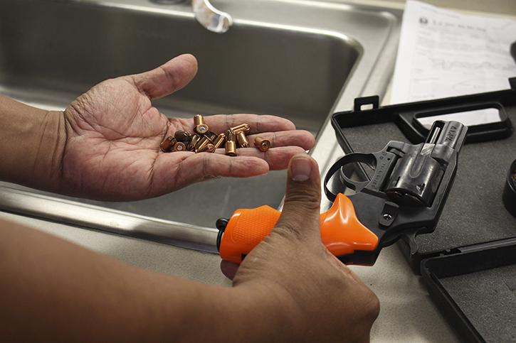 Officer Chuck Mabanag displays the non-lethal blank ammunition and starter pistol used during the active shooter drill in the Student Center on Friday. (Photo by Barbara Harvey)