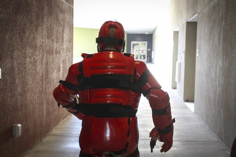 Officer Andrew Simon, wearing a protective Redman suit, stalks down the halls of the quad in the Student Center while shouting and firing blank ammunition during an active shooter drill Friday. The drills are intended to train students and staff on how to respond in the event of an active shooter on campus. (Photo by Barbara Harvey)