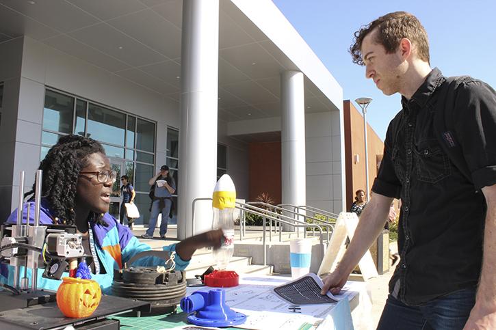 American River College student Cecile Thompson speaks with student Nemi McCarter about the Engineering Club. Thompson was chosen to participate in the NASA onsite experience at the Armstrong Flight Research Center in Edwards, California where she will create a rover that must be able to function properly if placed on the surface of Mars. (Photo by Lena DoBynes)