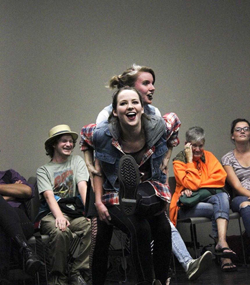 President of the Improv club Juliana Nassr uses the clubs treasurer Emily Peeler as a chair during a skit at its punk rock themed meeting on Thursday, Sept. 24. Volunteers acted in different skits and participated in games during the meeting that lasted form 10 p.m. to midnight on the American River College campus.  (Photo by Ashlynn Johnson)