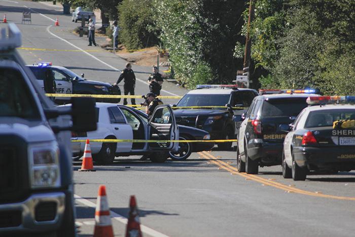 A police officer photographs the scene of a shooting that left one man dead on Cypress Avenue near Garfield Avenue on Thursday. Adrienee Ludd was killed by police during a confrontation, although he did not fire his gun. (Photo by John Ferrannini)