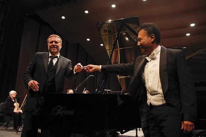 Award-winning pianist Jon Nakamatsu, right, gives a pen back to American River College Orchestra director Steven Thompson in the ARC Theater on Oct. 30, 2015. Nakamatsu was invited to sign the grand piano after performing with the orchestra. (Photo by John Ferrannini)