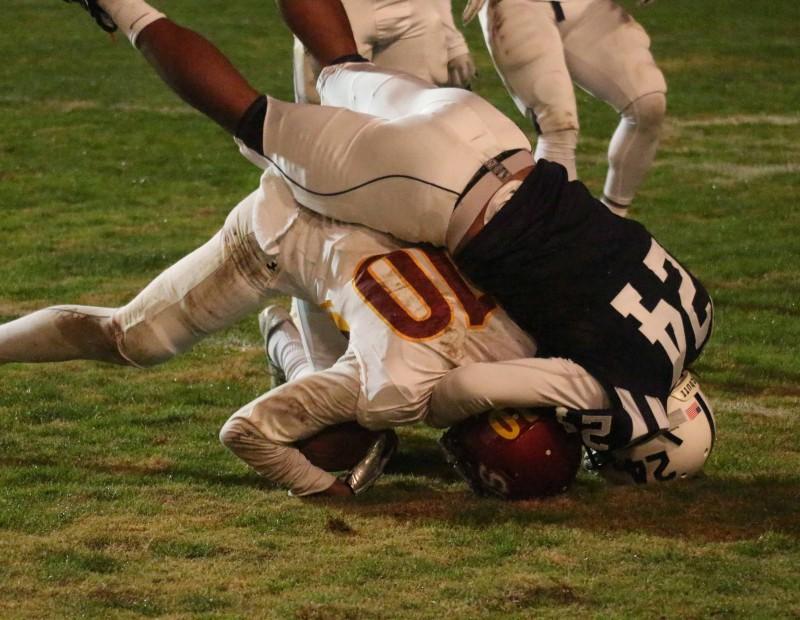American River College defensive back Dmitri Scott tackles Sacramento City College wide receiver Keylan Mack during ARC’s 38-18 win over SCC on Saturday, Nov. 14, 2015. (Photo by Barbara Harvey)