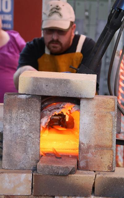 Art new media student Charles Kinter places his piece of metal into the forge in order to make the metal easier to shape in his class, ART 376: Functional Sculpture on Tuesday, November 24, 2015. The course focuses on working metal and using tools found in the blacksmithing market to make art that serves a purpose. Kinter said that working with the material has helped him in his art new media classes. (Photo by Lena DoBynes)