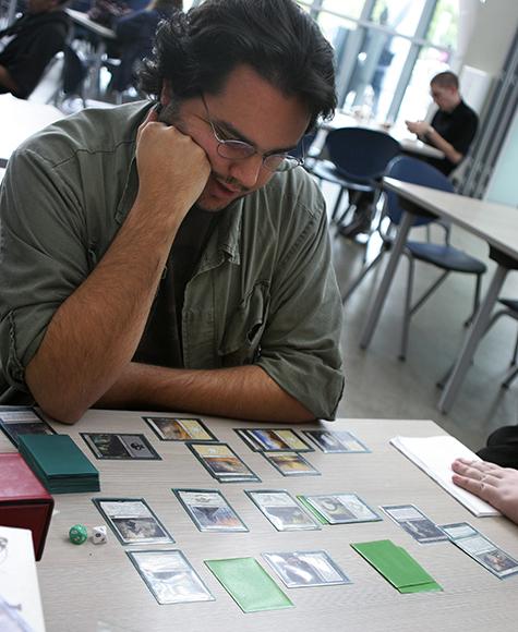 American River College student Casey Reynolds plays the card game Magic: The Gathering with friends in the Student Center. Tabletop games can be a good way to teach skills and knowledge to students. (Photo by Ashlynn Johnson)