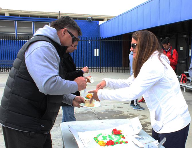 Water polo coaches Eric Black (left) and Bethani Black (right) eating cake for Erics birthday on the American River College pool deck. (Photo by Noor Abasi)