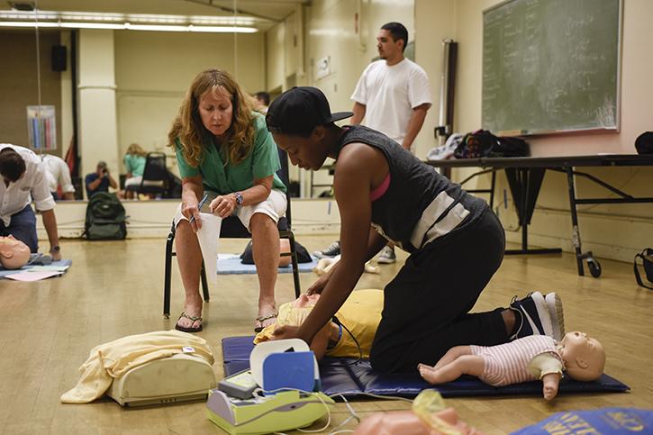 Professor Joanne English provides CPR/AED training to ARC student Alexis Holt in the main gym. Two classes yet to start in the spring 2016 semester will offer AED and CPR training. (Photo by Tracy Mapes)