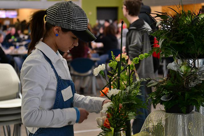 American River third year intern Nina Railean arranges a floral display for sale at the American River College student center Feb. 4, 2016. (Photo by Joe Padilla) 