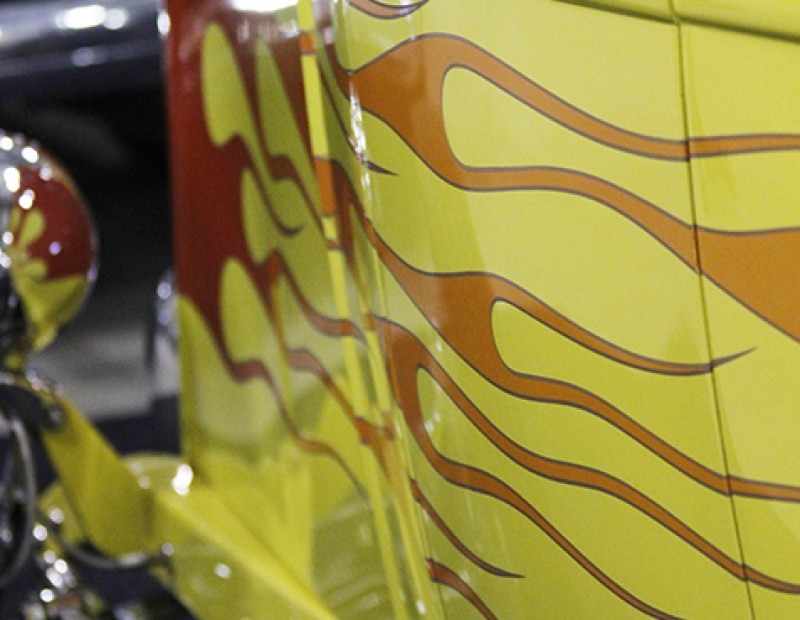 A yellow hot rod with a flame design running down the side of it, on display at the Sacramento Auto Rama at Cal Expo on Feb.12, 2016. (Photo by Matthew Nobert)