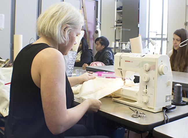 A student designer works on pieces for her collection for this springs fashion show on Feb. 10. (photo by Allante Morris)