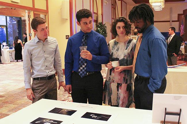 From left to right, The Initiatives Kyle Tyson, Anothony Johnson, Raven Kauba, and Darius Upshaw discuss the artwork that is on display and for sale at the First Annual Phi Theta Kappa Fundraiser Banquet on Mar. 12, 2016.  (Photograph by Timon Barkley)