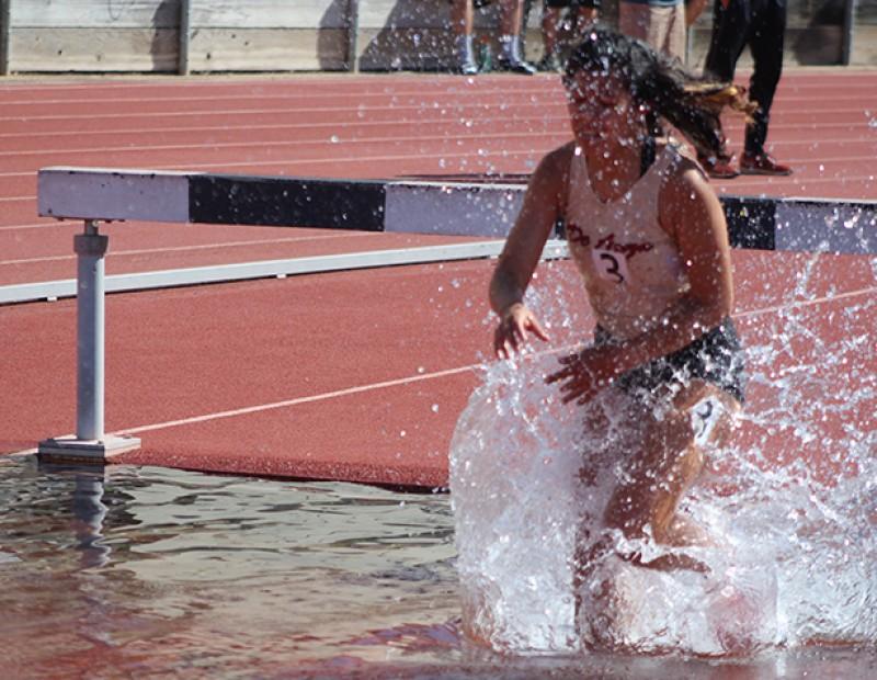 De Anza College runner Alejandra Flores lands in the water pit during the women’s 3000m steeplechase at the American River Invitational on March 26, 2016 at American River College. Flores finished 4th with a time of 12:49.23. (Photo by Mack Ervin III)