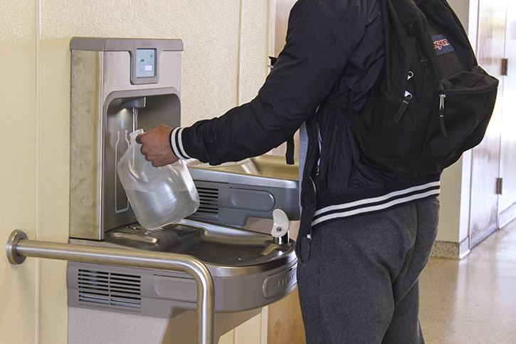 An American River College student refills a water jug with at a new refill station in Davis Hall. Five refill stations across campus during spring break and ARC will install more around campus in the coming weeks. (Photo by Itzin Alpizar).