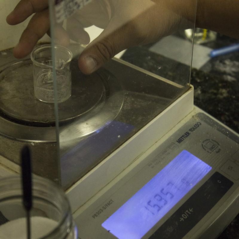 An organic chemistry student weighs the amount of product obtained from their extraction. The caffeine remained after the evaporation of the organic solvent, dichloromethane. (Photo by Timothy Lipuma)
