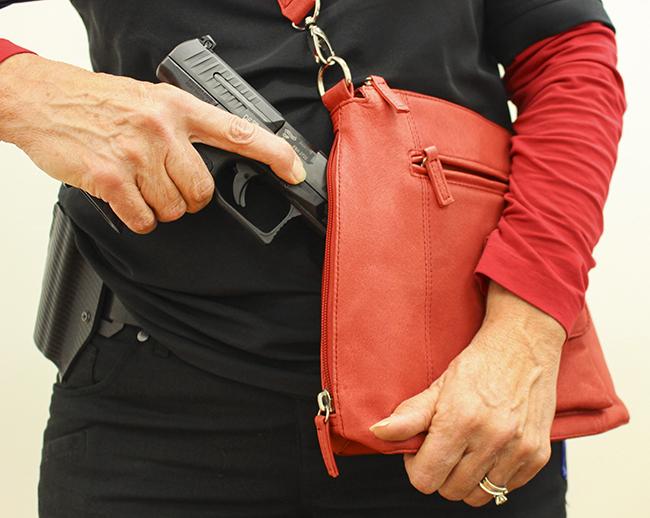 Debbie MacDonald poses with her gun and purse. MacDonald is the founder of the Well Armed Woman Sacramento chapter, which is an all womans firearm group. (Photo by Hannah Darden)