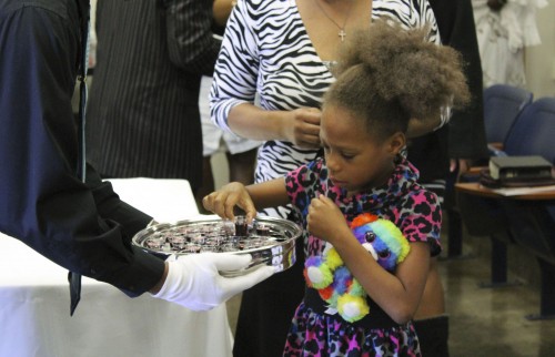 A young girl participates in communion during congregation on Feb. 7. Several children attend the church, including two of Pastor Kendall Young’s children. (Photo by Timon Barkley)