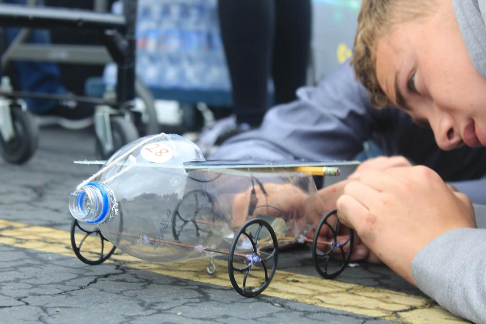 A high school student at puts the finishing touches on his solar car at SMUD solar  car competition on May 6.