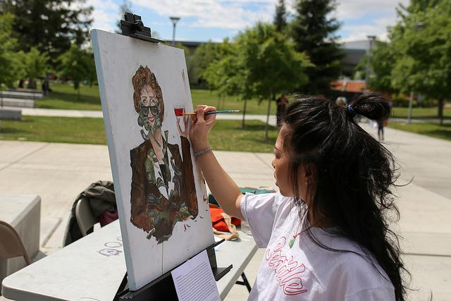 American River College student Kashia Lynhiavue paints one of her works titled Linda Katehi during the Artivism event held by UNITE at American River College on April 27, 2016. The event featured local activists, visual artisits and live performers. (Photo by Kyle Elsasser)